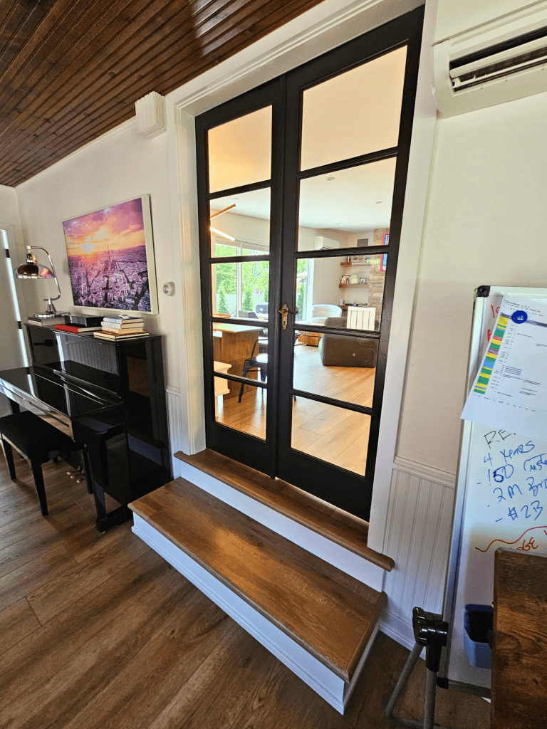 Modern interior glass door with wooden steps.