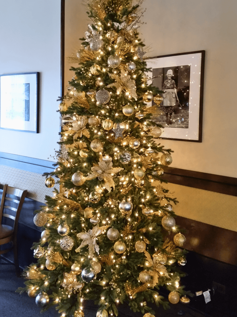 Decorated holiday Christmas tree with gold and silver ornaments, lights, and festive accents. Ideal for custom holiday space design.