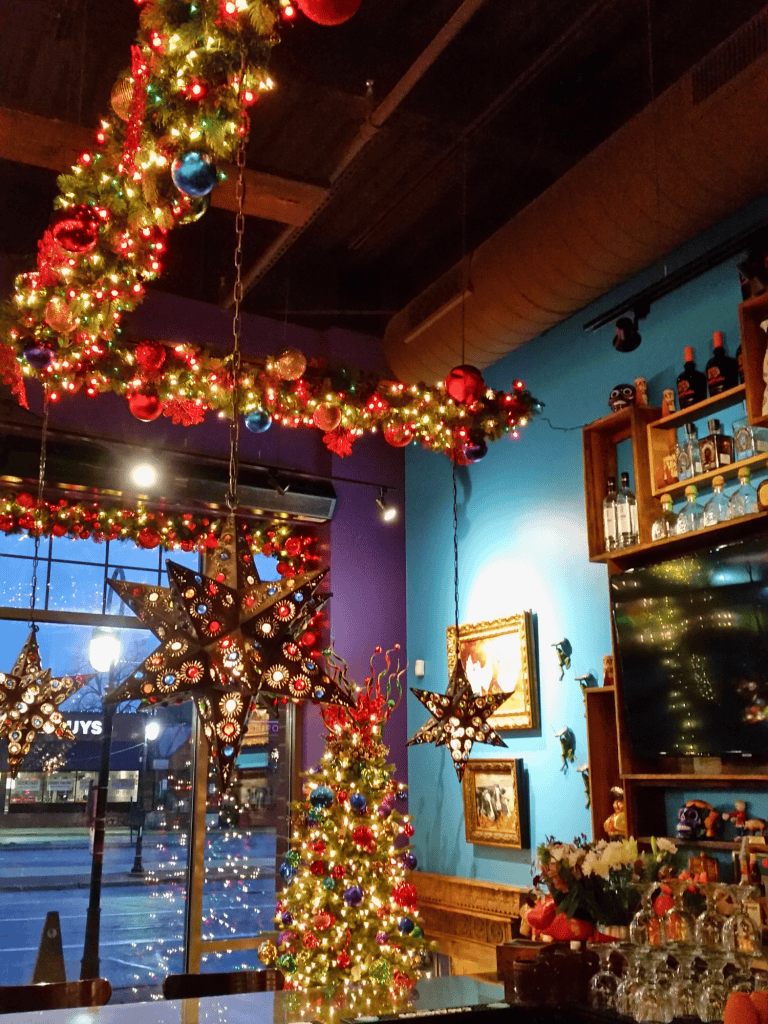 Decorative Christmas lighting, colorful ornaments, and star-shaped hanging lanterns in a cozy holiday setting.