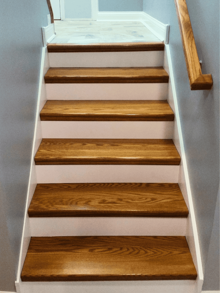 High-quality custom staircase with wooden treads and elegant white risers for modern interiors.